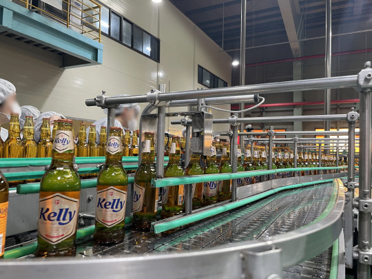 강원도 홍천군에 있는 하이트진로 강원공장 켈리 생산라인에서 완성된 제품이 자동화 기기에서 이동하고 있다. 하이트진로 제공